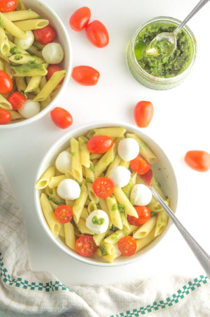 two bowls with caprese pasta salad with pesto