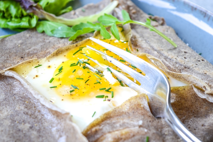 buckwheat crepe and egg cut by a fork