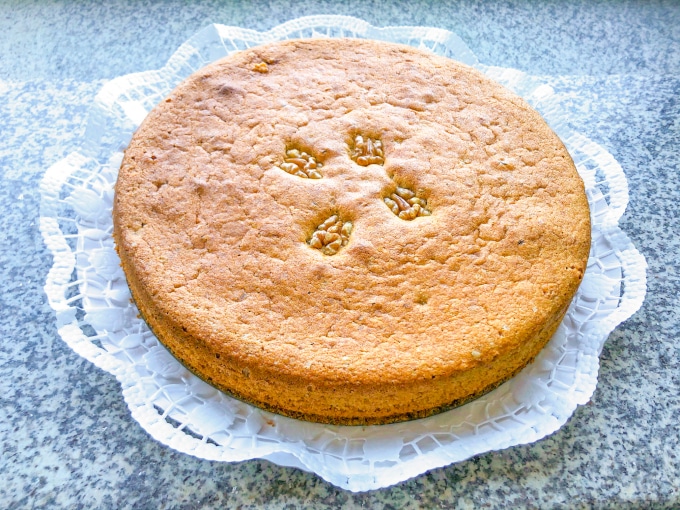 Close-up of a round low FODMAP cake decorated with walnuts