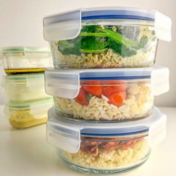 three filled lunchboxes and three dressing containers, both stacked