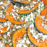 Detailed image of roast pumpkin wedges with feta and thyme leaves