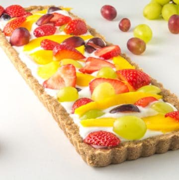 a low fodmap fruit tart surrounded by fresh fruit