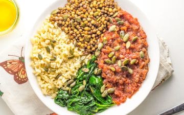 um bowl colorido com legumes, lentilhas e arroz integral